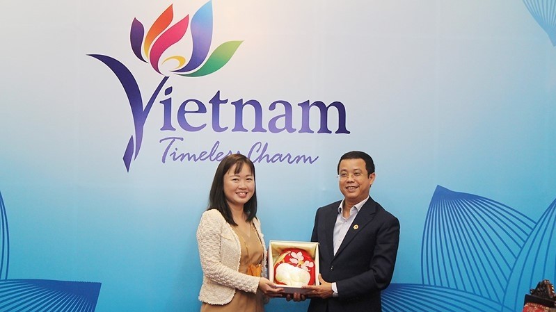 Deputy Director General of the VNAT Nguyen Le Phuc presents a commemorative gift to Teresa Tan. (Photo: TITC)