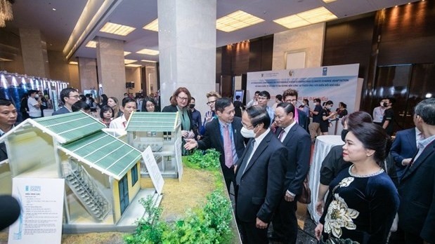 Delegates look at miniature model houses (Photo: VNA)