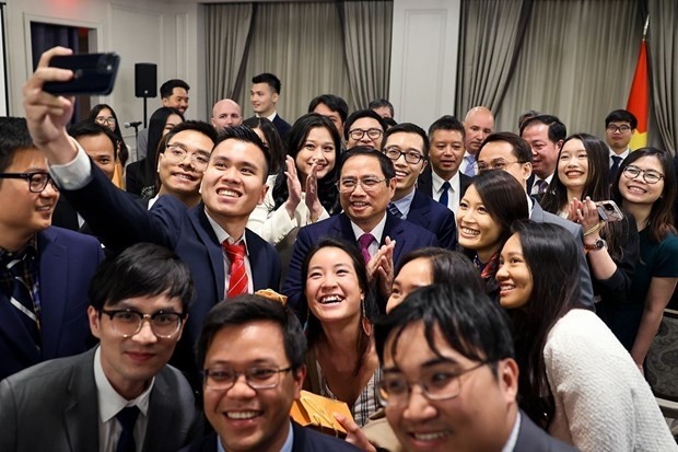 PM Pham Minh Chinh and young Vietnamese people in New York take a group selfie at the meeting on May 15 (Photo: VNA)
