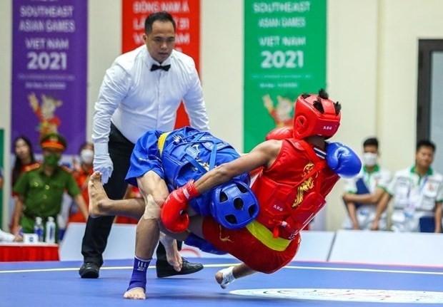 Vietnamese wushu artist Bui Truong Giang (in blue) defeats Jumanta from Indonesia to triumph the men's sanda 60kg on May 15. (Photo: VNA)