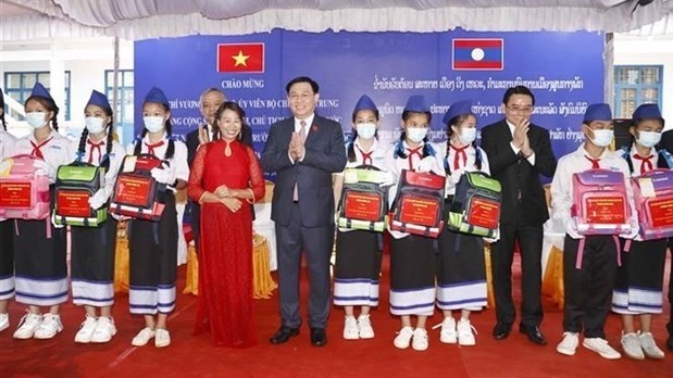 National Assembly Chairman Vuong Dinh Hue presents gifts to outstanding students at Ethnic Minority Boarding School in Champasak province of Laos on May 17. (Photo: VNA)