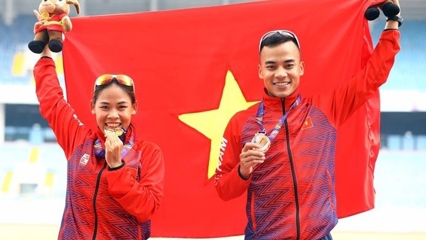 Nguyen Thi Thanh Phuc, gold medallist in the women's 20km walk and her brother Nguyen Thanh Ngung, bronze medallist in the men's 20km walk, pose for a photo. (Photo: VNA)