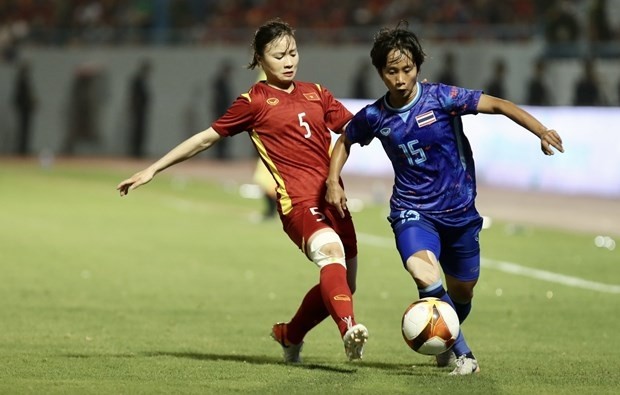 Vietnamese (in red) and Thai players vie for the ball at the final on May 21. (Photo: VNA)