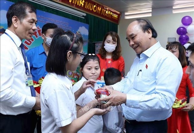 President Nguyen Xuan Phuc (R) presents gifts to children at the centre in Hanoi on May 31. (Photo: VNA)