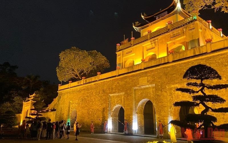 Tourists visit Thang Long Imperial Citadel at night.