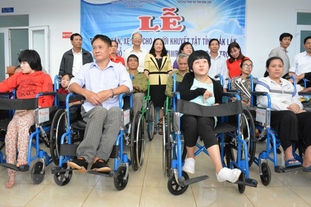 Persons with disabilities are presented with wheelchairs in Dak Lak province. (Photo: VNA)