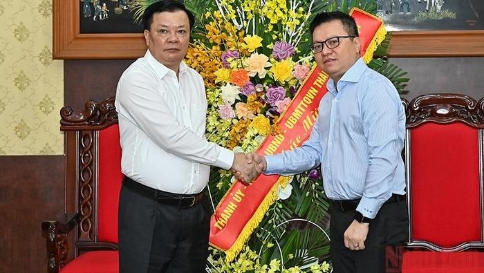 Secretary of Hanoi Municipal Party Committee Dinh Tien Dung (L) congratulates Nhan Dan Newspaper Editor-in-chief Le Quoc Minh. (Photo: NDO)