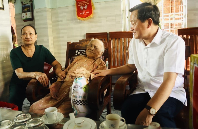 Deputy Prime Minister Le Minh Khai salutes Vietnamese heroic mother Phan Thi Huu in Dien Ban Ward. (Photo: NDO/Tan Nguyen)