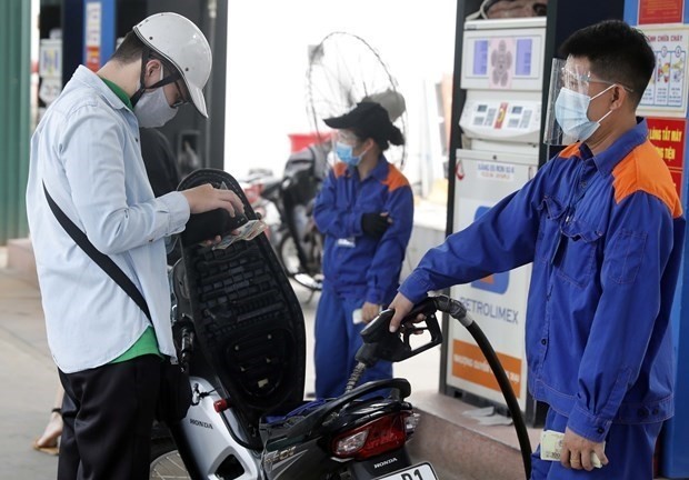 A motorcyclist has his vehile refilled at a gas station. Fuel prices were adjusted 19 times, including six decreases, in the first seven months of 2022. (Photo: VNA)