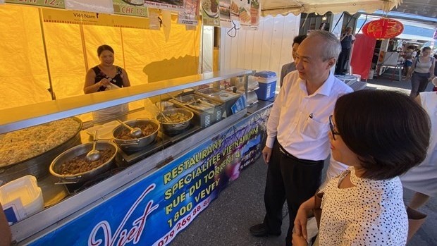 Ambassador Phung The Long visits the pavilion of the Maison Viet Restaurant at the weekend market in Vevey town. (Source: VNA)