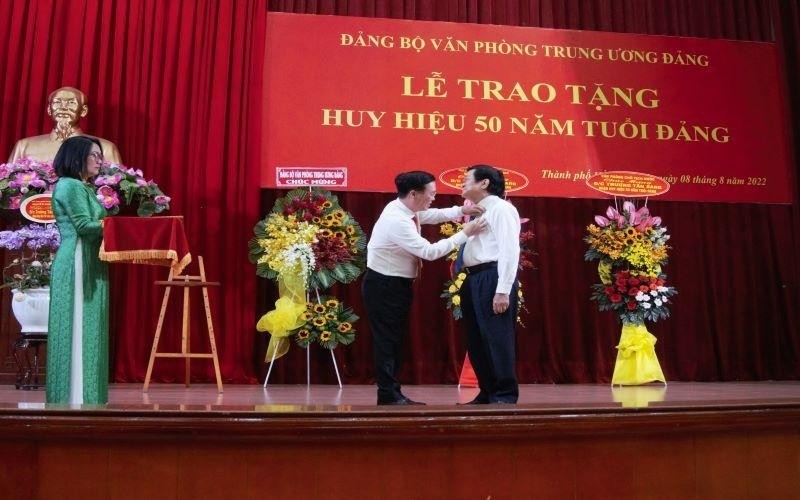 Politburo member Vo Van Thuong grants the 50-year Party membership insignia to former President Truong Tan Sang.