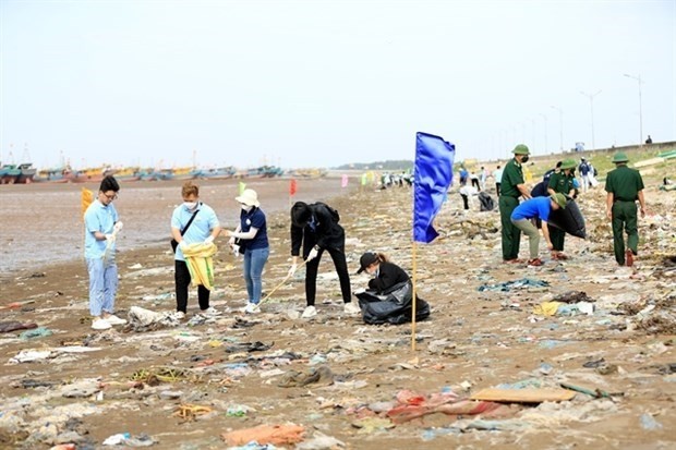 Members of Nam Dinh province’s youth union and officials from the Xuan Thuy National Park pick up trash on the beach in Giao Hai commune, Giao Thuy district. (Illustrative photo: VNA)