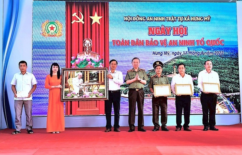The Minister of Public Security (middle) awards certificates of merit to collectives and individuals for outstanding achievements in the “All people protect national security” movement in Ca Mau.