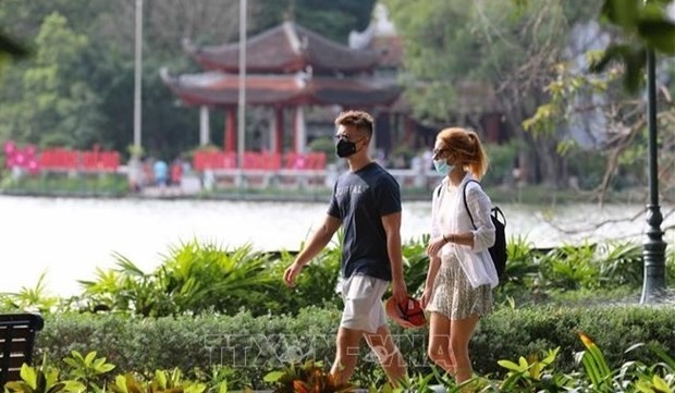 Foreign visitors go for a stroll near Hoan Kiem Lake in Hanoi. (Photo: VNA)
