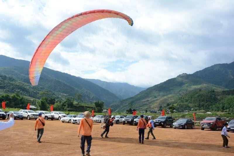 Tourists preparing to paraglide over the golden season of Mu Cang Chai.