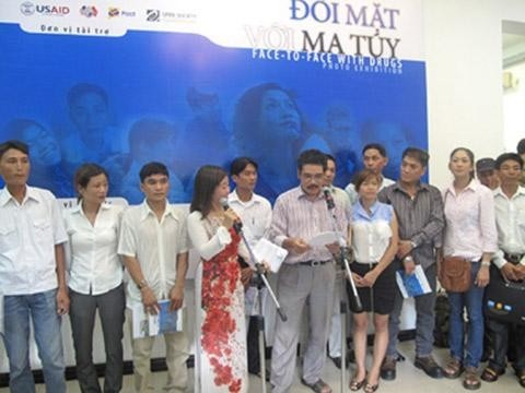 Photographer Pham Hoai Thanh (center)  with some people in his photo exhibition