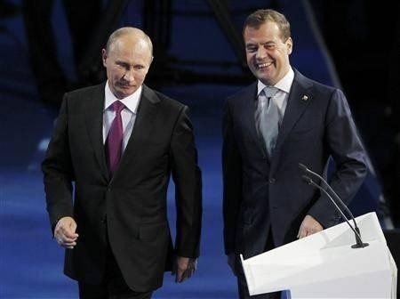 Russia's President Dmitry Medvedev (R) and Prime Minister Vladimir Putin walk along the stage to address the audience du