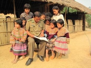 An official from the Na Hy Border Guard reads books to children at the Nam Chua 5 school in Na Hy commune, Muong Nhe dis