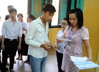 Proctor checking student information at Trung Vuong Secondary School Examination Council in Hanoi’s Hoan Kiem district