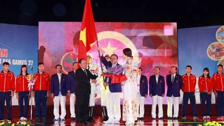 Minister Hoang Tuan Anh (left) presents the national flag to Lam Quang Thanh, head of the Vietnam sports delegation 