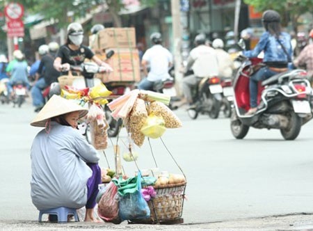 A street vendor observes the buzzing traffic.