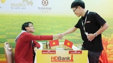 Truong Son (left) declares victory over Quang Liem in their latest meeting at the 2014 HDBank Cup International Open Chess Tournament.