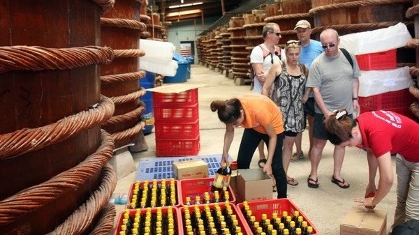 Foreign tourists visit a fish sauce processing facility in An Thoi commune, Phu Quoc. (Image credit: VNA)