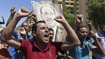 Iraqis display placards bearing a picture of embattled Prime Minister Nouri al-Maliki during a demonstration in Baghdad, Iraq, August 11.