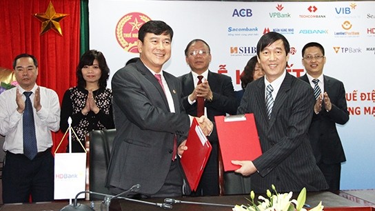 A representative from HDBank (left) signs an agreement with the General Department of Taxation