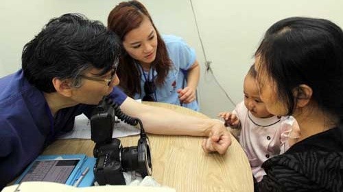 A doctor from the PVNF is offering free medical checks-up for a child with cleft lip at the 175 Military Hospital. (Credit: qdnd.vn)