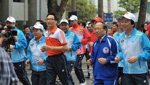 Deputy PM Vu Duc Dam (in orange) and officials of the sports sector join the run.