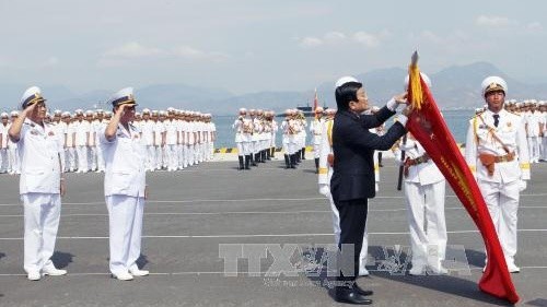 The State leader pins the insignia of “Hero of the People’s Armed Forces” onto the flag of the navy.