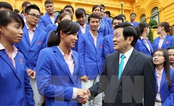 President Truong Tan Sang (left) congratulates swimmer Nguyen Thi Anh Vien at a reception in Hanoi on June 23 for coaches and athletes who achieved top results at 28th SEA Games (Photo: VNA)