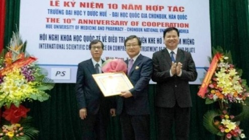 Professor Shin Hyu-Geun (centre) receives the Health Ministry’s insignia ‘For People’s Health’. (Image credit: NDO)