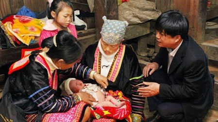 A village midwife (left) takes care of a new-born in the northern mountainous province of Dien Bien (Photo: Duong Ngoc/ VNA)