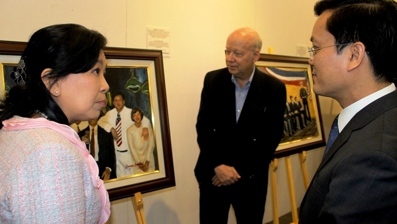 Artist Soraya Runckel introduces her paintings to Deputy Minister of Foreign Affairs Ha Kim Ngoc. (Credit: dangcongsan.vn)