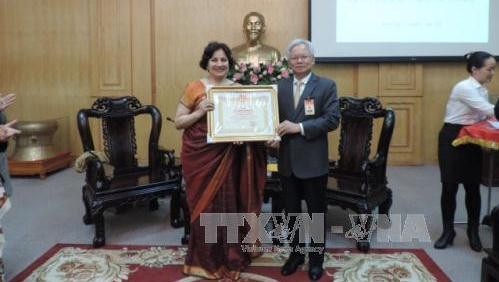 Indian Ambassador to Vietnam Preeti Saran receives the insignia “For the course of building and developing the Ho Chi Minh National Academy of Politics”. (Credit: VNA)