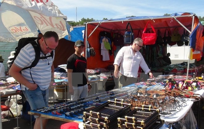 Foreign visitors buying souvenirs at a market in Nha Trang city (Credit: VNA)
