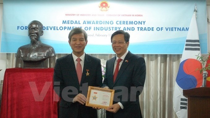 Ambassador Pham Huu Chi (R) grants the insignia to Chung Hae-moon (Photo: VNA)