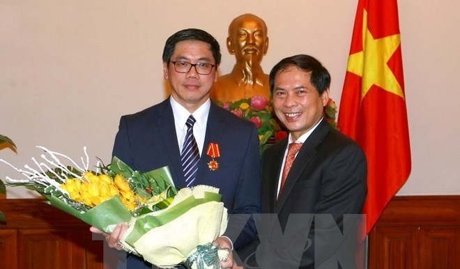 Deputy Foreign Minister Bui Thanh Son (R) congratulates Singaporean Ambassador to Vietnam Ng Tech Hean (Photo: VNA)