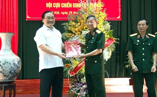 Secretary of the Hanoi municipal Party Committee Hoang Trung Hai with the war veterans (Credit: HNMO)