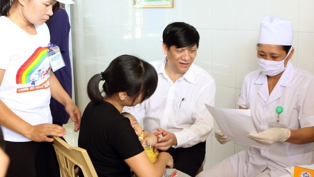 Deputy Minister of Health Nguyen Thanh Long inspects a vaccine injection held after the meeting at a clinic in Quang Binh commune, Quang Xuong district, Thanh Hoa province (Photo: VNA)