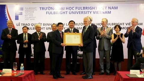 Chairman of Ho Chi Minh City municipal People’s Committee Nguyen Thanh Phong presents the decision to establish the Fulbright University Vietnam to Chairman of the FUV Board of Trustees Bob Kerrey. (Credit: VNA)