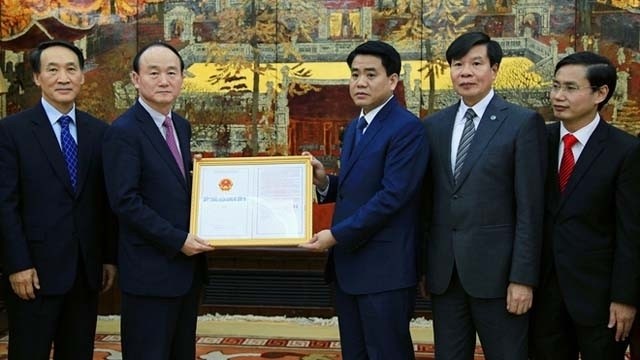 Hanoi Chairman Nguyen Duc Chung grants an investment licence to Samsung.