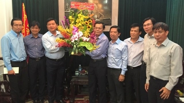 Politburo member Dinh La Thang (third from left) presents flowers to Sai Gon Giai Phong newspaper’s editorial board 