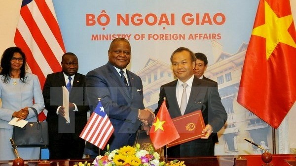 Liberian Ambassador to China D. McKinley Thomasand (L) and Deputy Foreign Minister Vu Hong Nam at the signing ceremony. (Credit: VNA)