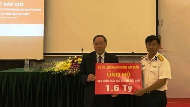 Senior Lieutenant General Nguyen Van Rinh (left) receives a donation worth VND1.6 billion from the High Command of the Vietnamese People's Navy to support AO victims. (Credit: NDO)