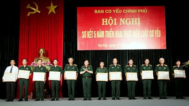 General Ngo Xuan Lich presents the Certificate of Merit of the Minister of Defence for typical individuals who have reaped outstanding achievements in implementing the Cryptography Law. (Credit: antoanthongtin.vn)