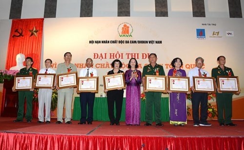 Head of the Party Central Committee’s Mass Mobilisation Commission Truong Thi Mai (fifth right) with standout individuals and groups recognised for their contributions (Credit: qdnd.vn)