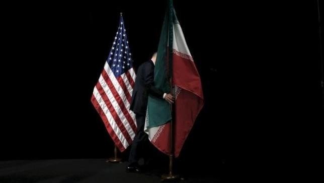 A staff member removes the Iranian flag from the stage during the Iran nuclear talks in Vienna, Austria July 14, 2015. (Credit: Reuters)